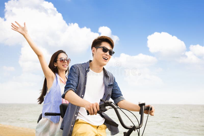 Jonge paar berijdende fiets op het strand stock foto's Jonge paar berijdende fiets op het strand stock foto's