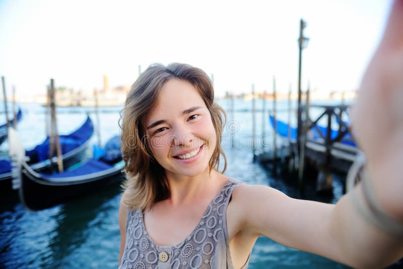 Jonge reiziger die selfie foto met gondels op de achtergrond in Venetië, Italië maken stock foto's Jonge reiziger die selfie foto met gondels op de achtergrond in Venetië, Italië maken stock foto's