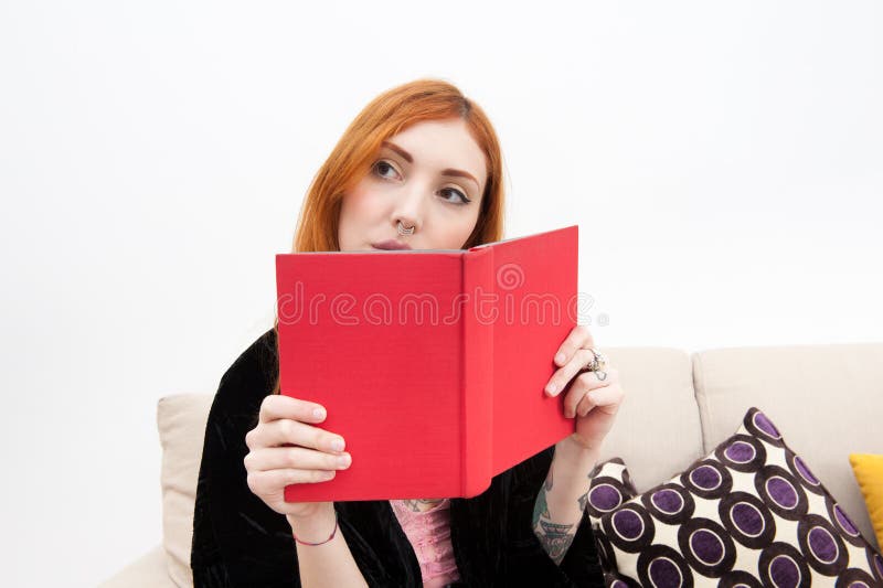 Jonge roodharigevrouw die een boek lezen stock afbeeldingen Jonge roodharigevrouw die een boek lezen stock afbeeldingen
