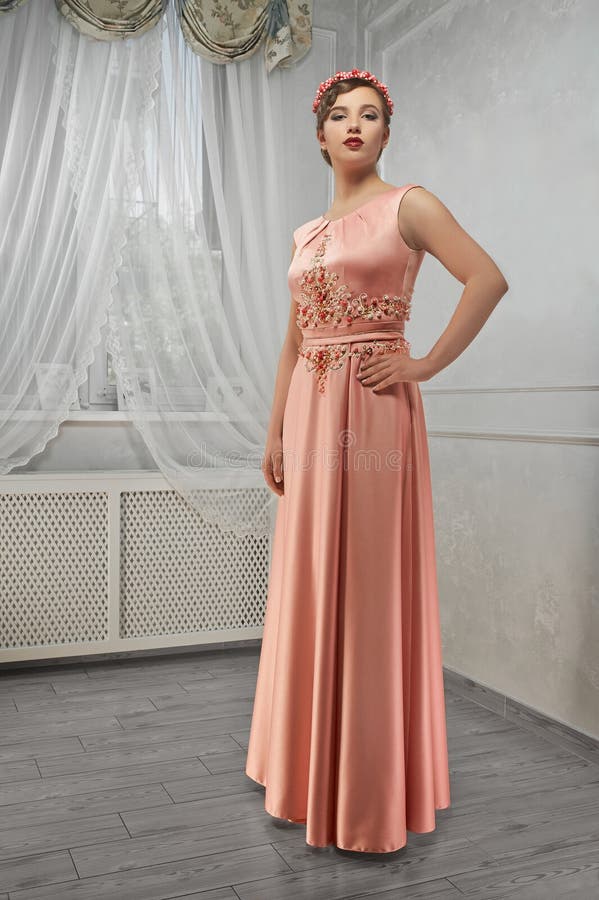 Jonge schoonheid, mooie vrouw in perzik lange kleding, hand op heup, loo royalty-vrije stock afbeelding Jonge schoonheid, mooie vrouw in perzik lange kleding, hand op heup, loo royalty-vrije stock afbeelding