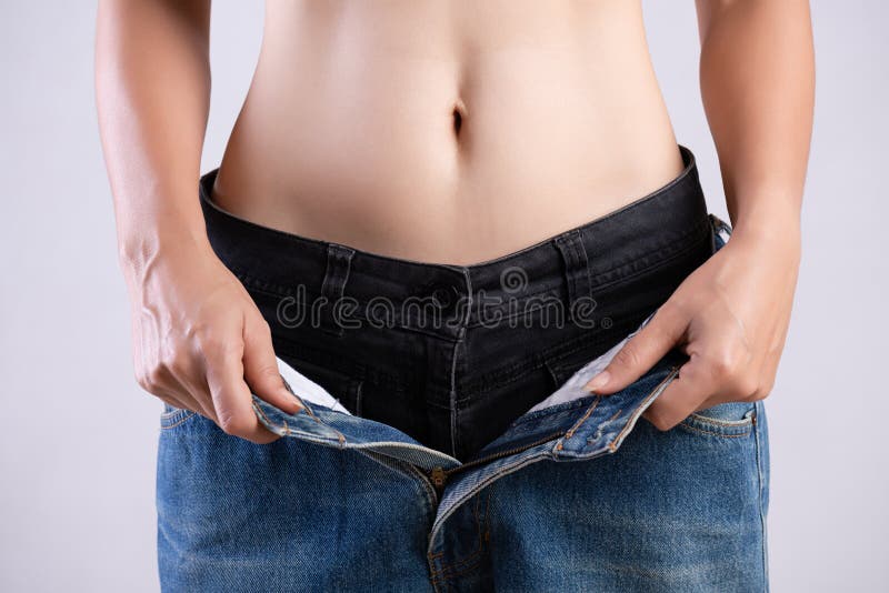Jonge slanke vrouw in overmaatse jeans Geschikte vrouw die te grote broek dragen Gezondheidszorg en te verminderen de levensstijl royalty-vrije stock afbeeldingen Jonge slanke vrouw in overmaatse jeans Geschikte vrouw die te grote broek dragen Gezondheidszorg en te verminderen de levensstijl royalty-vrije stock afbeeldingen