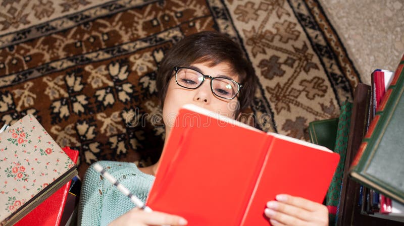 Jonge student die terwijl het bestuderen liggen stock fotografie Jonge student die terwijl het bestuderen liggen stock fotografie