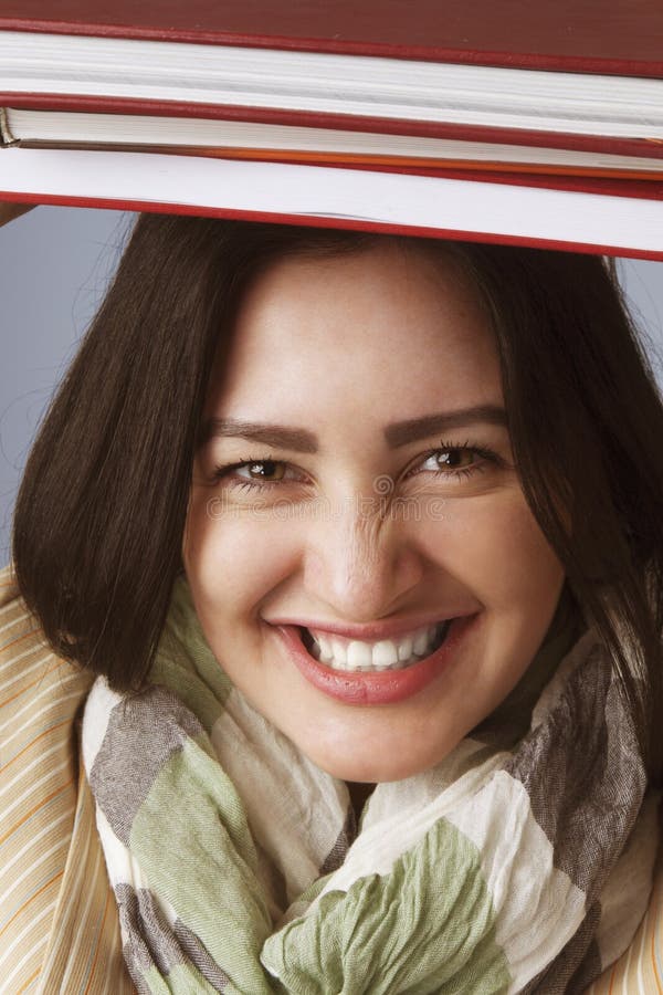 Jonge Student Girl Balancing Books op haar Hoofd & x28; Onderwijs en Se stock foto Jonge Student Girl Balancing Books op haar Hoofd & x28; Onderwijs en Se stock foto