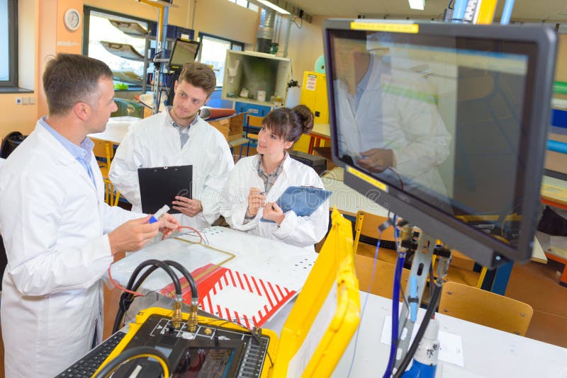 Jonge studenten die aan wetenschapsproject samenwerken in laboratorium stock fotografie Jonge studenten die aan wetenschapsproject samenwerken in laboratorium stock fotografie
