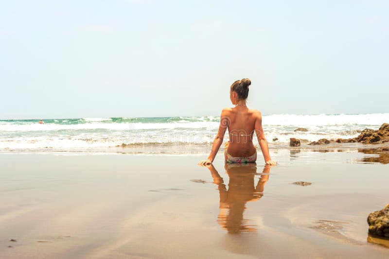 Jonge tienerzitting op het strand van de Atlantische Oceaan stock fotografie Jonge tienerzitting op het strand van de Atlantische Oceaan stock fotografie