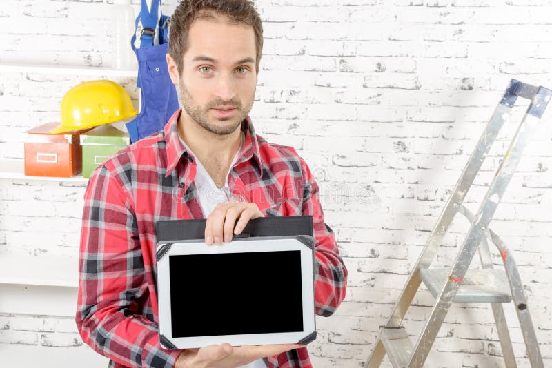 Jonge timmerman die het scherm op digitale tablet tonen stock foto's Jonge timmerman die het scherm op digitale tablet tonen stock foto's