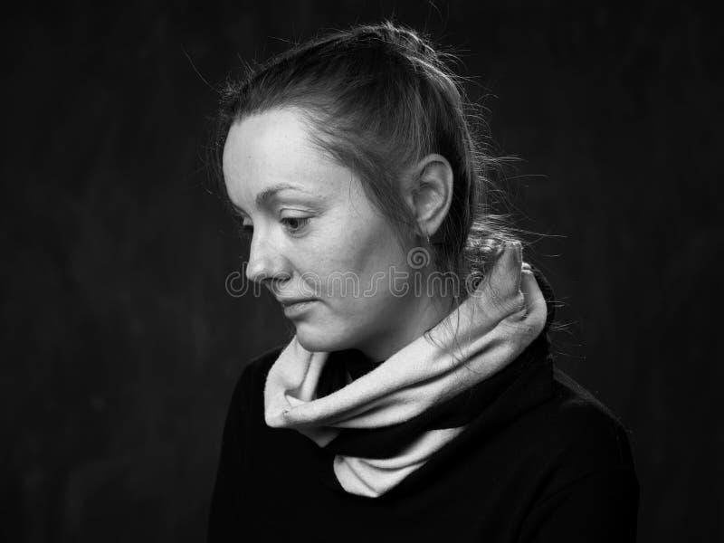 Portrait of a young sad disoriented woman, side view grey background. Portrait of a young sad disoriented woman, side view grey background