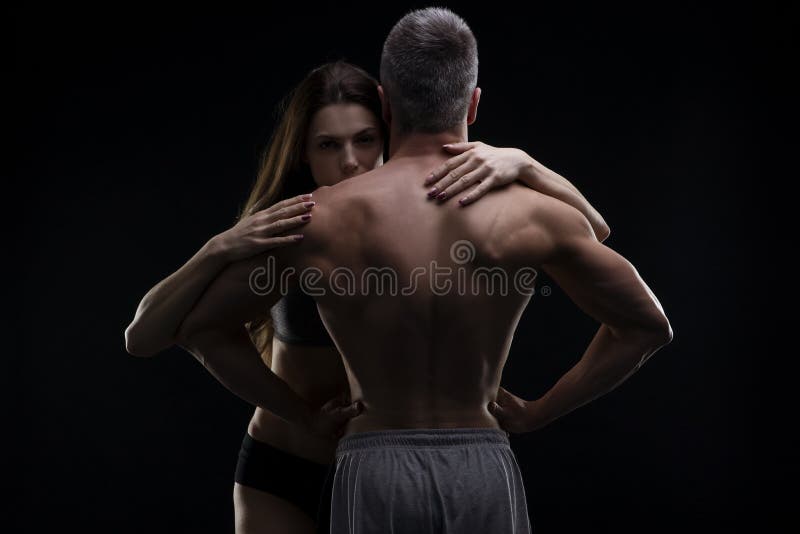 Jonge volwassen spierman en vrouw Sexy paar op zwarte achtergrond royalty-vrije stock afbeeldingen Jonge volwassen spierman en vrouw Sexy paar op zwarte achtergrond royalty-vrije stock afbeeldingen