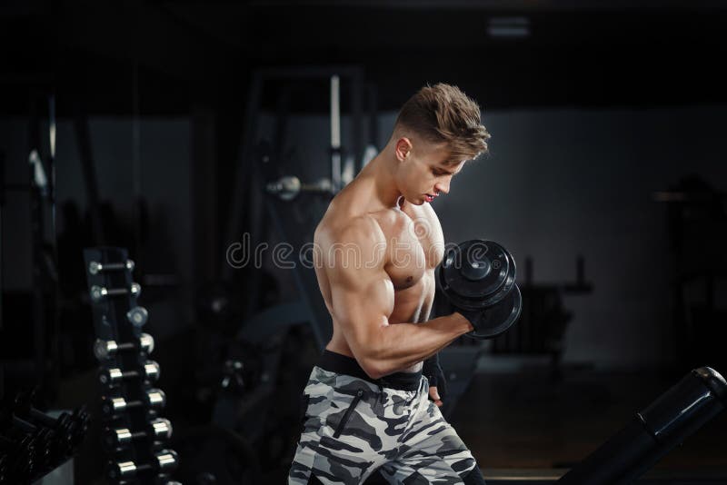 Jonge volwassen vrouw die in gymnastiek uitwerken, die bicep krullen met hulp van haar persoonlijke trainer doen stock afbeeldingen Jonge volwassen vrouw die in gymnastiek uitwerken, die bicep krullen met hulp van haar persoonlijke trainer doen stock afbeeldingen