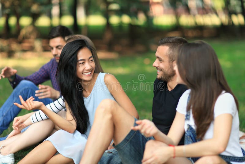 Jonge vrolijke mannen en vrouwen die in park spreken stock foto's Jonge vrolijke mannen en vrouwen die in park spreken stock foto's