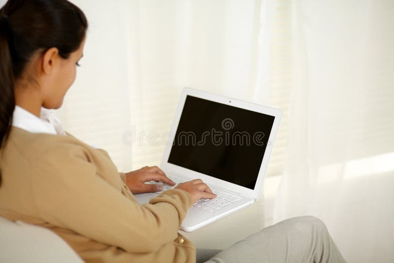 Portrait of a young woman working on laptop computer. Portrait of a young woman working on laptop computer