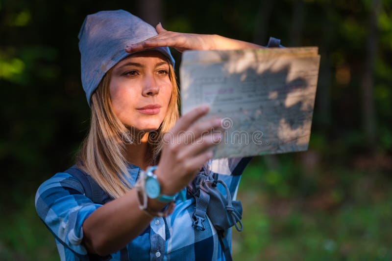 Jonge vrouw die alleen in het hout lopen die een kaart houden De wandeling bedriegt royalty-vrije stock fotografie Jonge vrouw die alleen in het hout lopen die een kaart houden De wandeling bedriegt royalty-vrije stock fotografie
