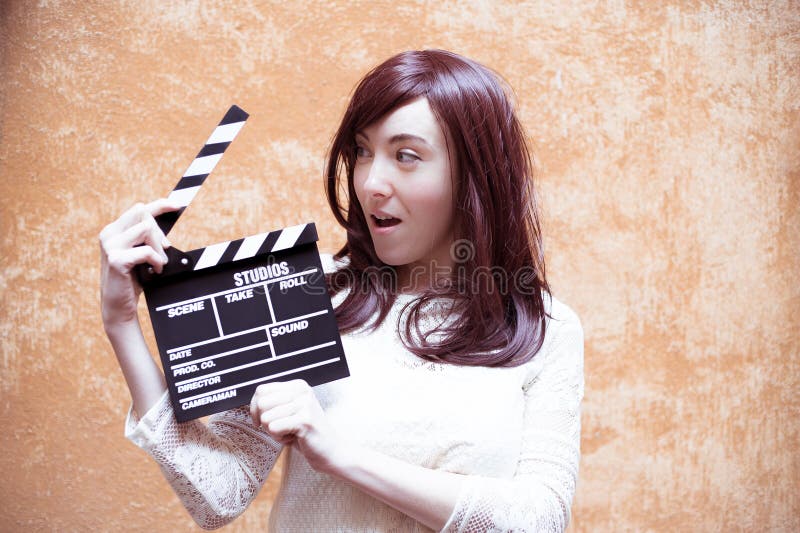Jonge vrouw die in de stijl van de jaren '70hippie met clapperboard glimlachen royalty-vrije stock foto's Jonge vrouw die in de stijl van de jaren '70hippie met clapperboard glimlachen royalty-vrije stock foto's