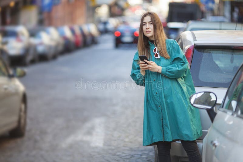 jonge vrouw die een aanvraag voor een mobiele telefoon gebruikt om een taxi aan te vragen royalty-vrije stock foto's jonge vrouw die een aanvraag voor een mobiele telefoon gebruikt om een taxi aan te vragen royalty-vrije stock foto's