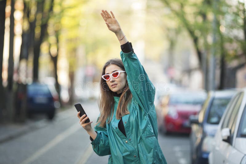 jonge vrouw die een mobiele telefoon gebruikt om een taxi te bellen royalty-vrije stock fotografie jonge vrouw die een mobiele telefoon gebruikt om een taxi te bellen royalty-vrije stock fotografie