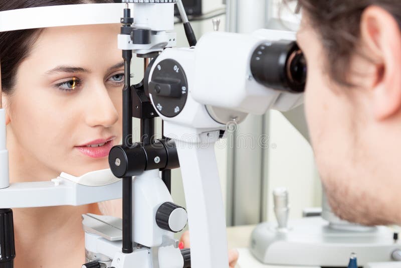 Jonge vrouw die een slit-lamp oogtest in oftalmologiekliniek hebben