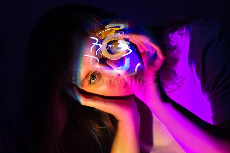 Jonge vrouw die een virtuele werkelijkheid gebruikt in een futuristische kamer met kleurrijke lampen royalty-vrije stock fotografie Jonge vrouw die een virtuele werkelijkheid gebruikt in een futuristische kamer met kleurrijke lampen royalty-vrije stock fotografie