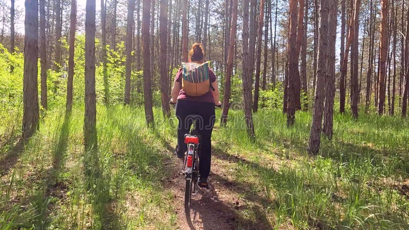 Jonge vrouw die fietst in het bos