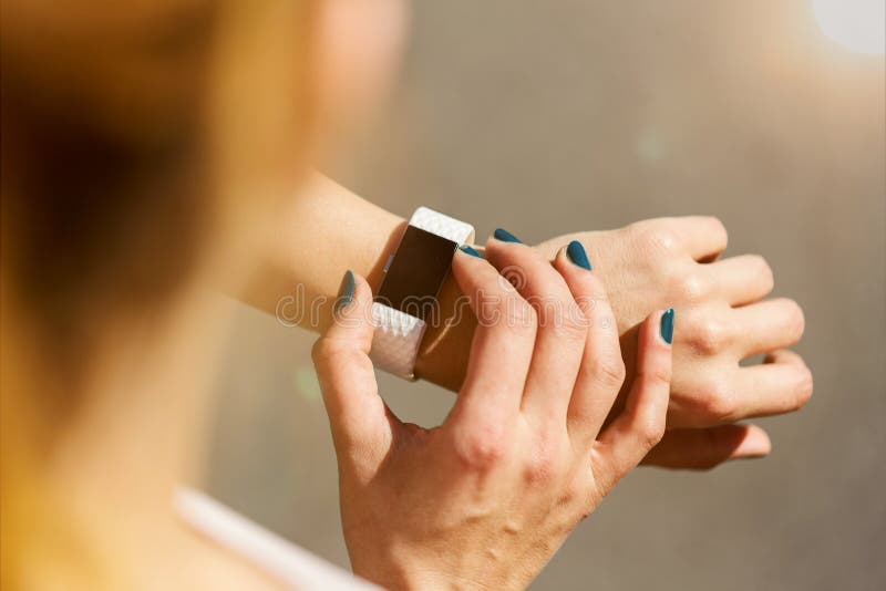 Jonge vrouw die haar geschiktheidshorloge controleren royalty-vrije stock afbeeldingen Jonge vrouw die haar geschiktheidshorloge controleren royalty-vrije stock afbeeldingen