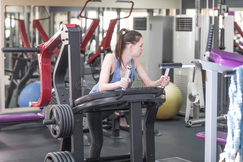 Jonge vrouw die haar vierlingen werken bij machinepers in de gymnastiek royalty-vrije stock fotografie Jonge vrouw die haar vierlingen werken bij machinepers in de gymnastiek royalty-vrije stock fotografie