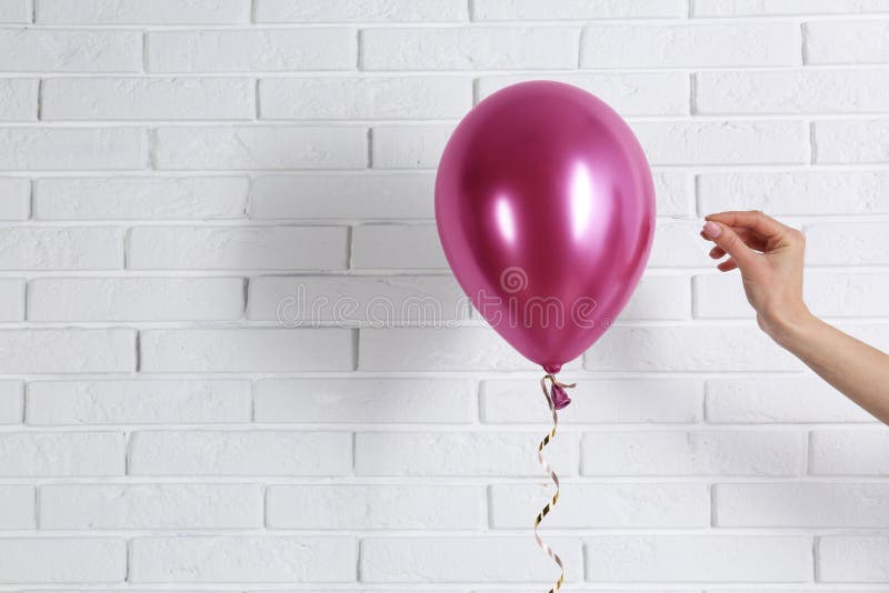 Jonge vrouw die heldere ballon doordringen dichtbij muur, ruimte voor tekst royalty-vrije stock foto's Jonge vrouw die heldere ballon doordringen dichtbij muur, ruimte voor tekst royalty-vrije stock foto's