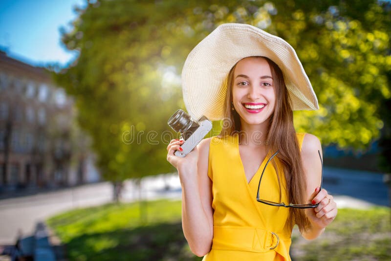 Jonge vrouw die in het stadspark reizen met camera gekleed in ye royalty-vrije stock afbeeldingen Jonge vrouw die in het stadspark reizen met camera gekleed in ye royalty-vrije stock afbeeldingen