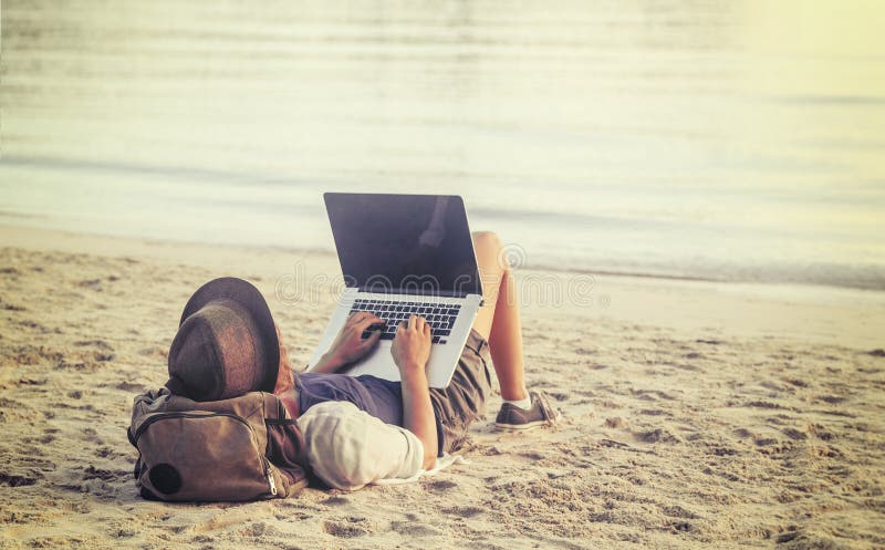 Jonge vrouw die laptop computer op een strand met behulp van Het freelance werk bedriegt