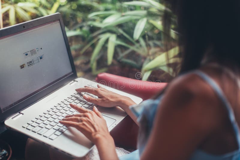 Jonge vrouw die met laptop zitting bij koffie werken stock afbeelding Jonge vrouw die met laptop zitting bij koffie werken stock afbeelding