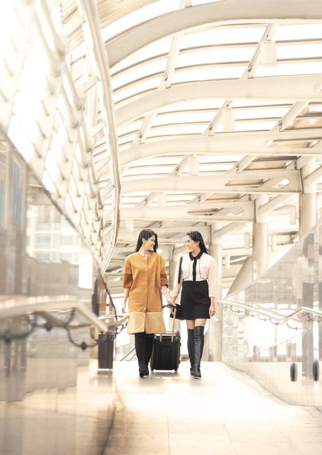Jonge vrouw die met reiszak bij de luchthaven voor reizigerstoerisme lopen stock afbeeldingen Jonge vrouw die met reiszak bij de luchthaven voor reizigerstoerisme lopen stock afbeeldingen
