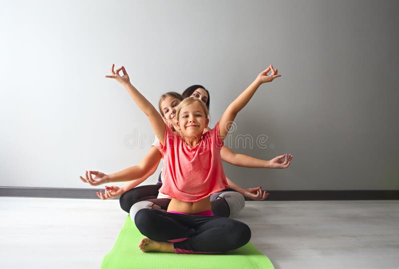 Jonge vrouw die pret met jonge geitjes hebben die yoga doen royalty-vrije stock fotografie Jonge vrouw die pret met jonge geitjes hebben die yoga doen royalty-vrije stock fotografie