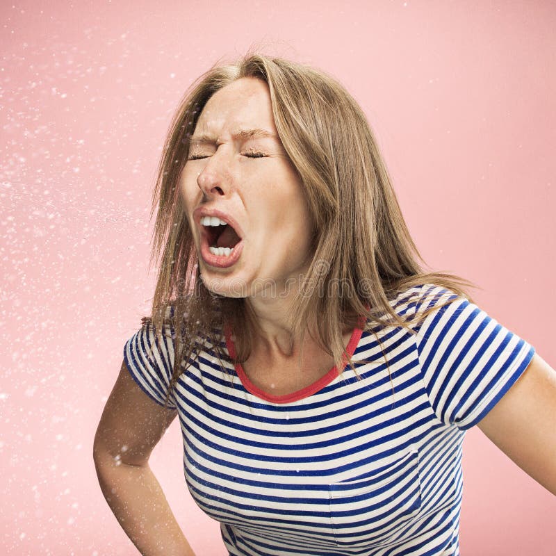 Jonge vrouw die, studioportret niezen stock foto Jonge vrouw die, studioportret niezen stock foto