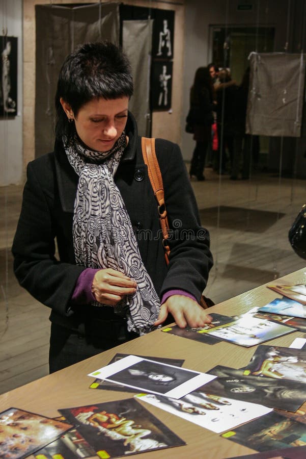 Jonge vrouw het letten op boeken op achtergrond van fotografie Binnenland van boekhandel stock fotografie Jonge vrouw het letten op boeken op achtergrond van fotografie Binnenland van boekhandel stock fotografie