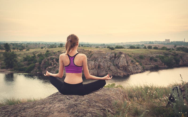 Jonge vrouw het praktizeren yoga op de heuvel bij zonsondergang stock foto's Jonge vrouw het praktizeren yoga op de heuvel bij zonsondergang stock foto's