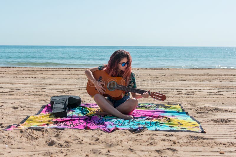 Jonge vrouw het spelen gitaar op het strand royalty-vrije stock afbeelding Jonge vrouw het spelen gitaar op het strand royalty-vrije stock afbeelding