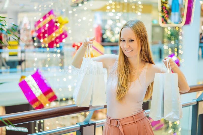 Jonge vrouw in Kerstmiswandelgalerij met Kerstmis het winkelen Schoonheidsbu royalty-vrije stock afbeeldingen Jonge vrouw in Kerstmiswandelgalerij met Kerstmis het winkelen Schoonheidsbu royalty-vrije stock afbeeldingen
