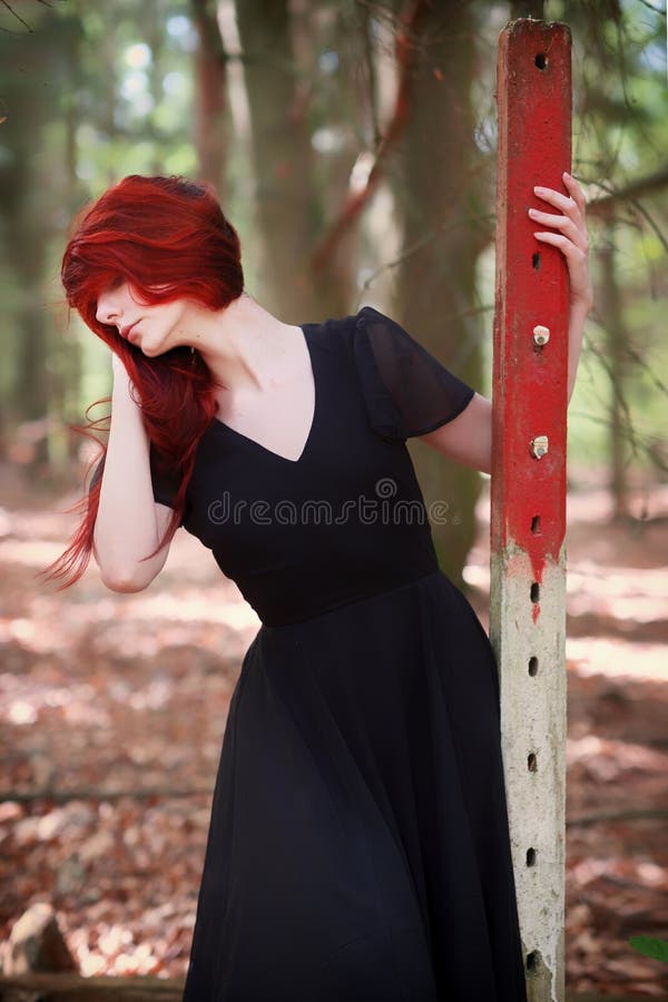 Jonge vrouw met rood haar in elegante avondjurk in het bos royalty-vrije stock foto Jonge vrouw met rood haar in elegante avondjurk in het bos royalty-vrije stock foto