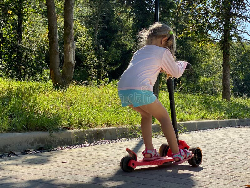 Jonge vrouw met scooter in het park stock foto Jonge vrouw met scooter in het park stock foto