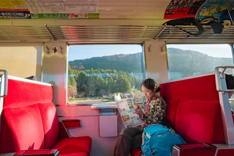 Jonge vrouwelijke reiziger met rugzak met plattegronplanning vakantie op vakantieontspanning op de trein in nikko, Japan royalty-vrije stock afbeeldingen Jonge vrouwelijke reiziger met rugzak met plattegronplanning vakantie op vakantieontspanning op de trein in nikko, Japan royalty-vrije stock afbeeldingen