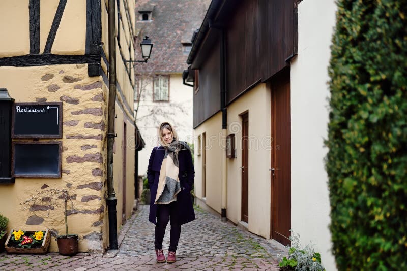 Jonge vrouwelijke toerist die in de historische stad van Colmar de Elzas, Frankrijk lopen stock afbeelding Jonge vrouwelijke toerist die in de historische stad van Colmar de Elzas, Frankrijk lopen stock afbeelding