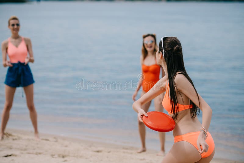 jonge vrouwelijke vrienden in het swimwear spelen met vliegende schijf stock fotografie jonge vrouwelijke vrienden in het swimwear spelen met vliegende schijf stock fotografie