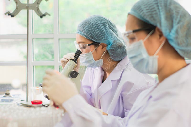 Jonge vrouwelijke wetenschapper in beschermende glazen en handschoenen, gebruik microscoop om onderzoek uit te voeren, concepttes royalty-vrije stock foto's Jonge vrouwelijke wetenschapper in beschermende glazen en handschoenen, gebruik microscoop om onderzoek uit te voeren, concepttes royalty-vrije stock foto's
