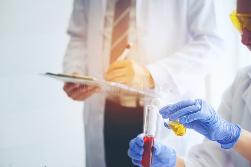 Jonge vrouwelijke wetenschapper die zich met techer in laboratoriumarbeider het maken bevinden royalty-vrije stock fotografie Jonge vrouwelijke wetenschapper die zich met techer in laboratoriumarbeider het maken bevinden royalty-vrije stock fotografie