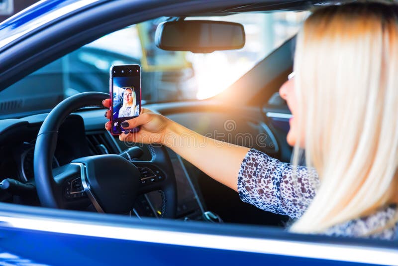 Jonge vrouwenbestuurder die een selfie in haar auto nemen royalty-vrije stock foto Jonge vrouwenbestuurder die een selfie in haar auto nemen royalty-vrije stock foto