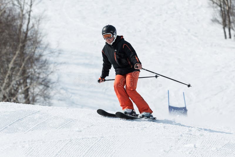 Jonge vrouwenskiër die onderaan de ski uit berg op zonnige dag komen stock foto's Jonge vrouwenskiër die onderaan de ski uit berg op zonnige dag komen stock foto's