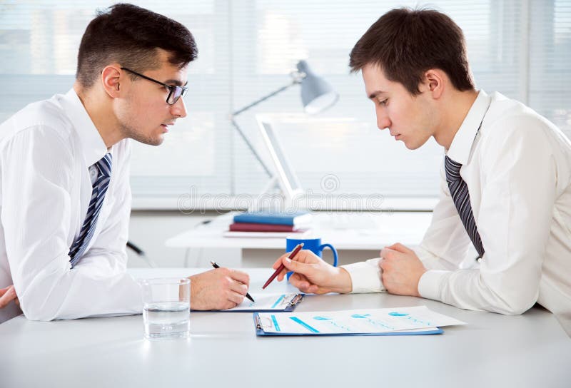 Jonge zakenlieden die een project bespreken stock afbeelding Jonge zakenlieden die een project bespreken stock afbeelding