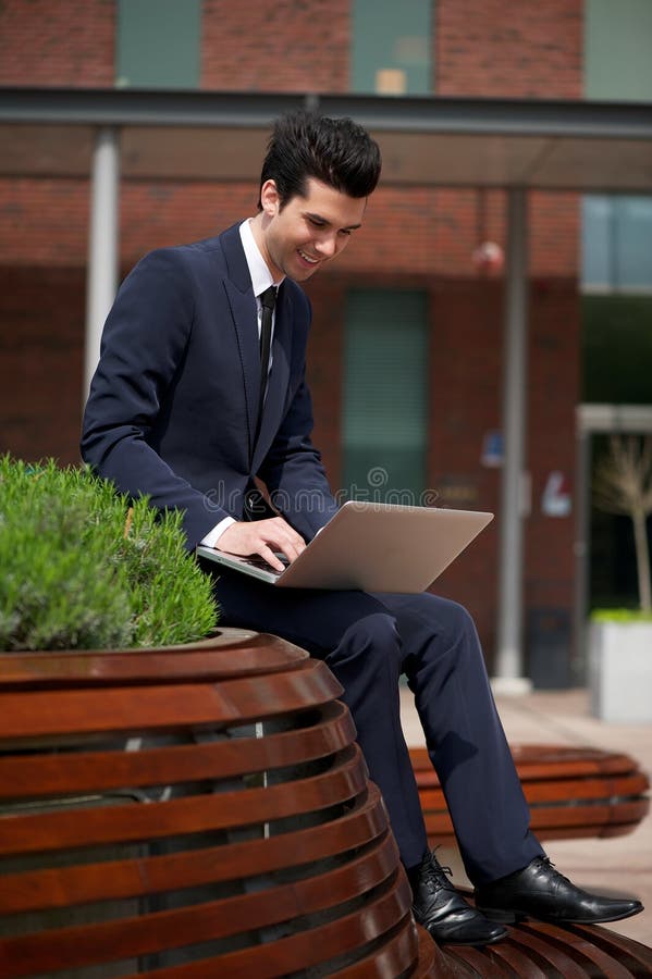 Jonge zakenman die aan laptop buiten het bureau werken royalty-vrije stock foto's Jonge zakenman die aan laptop buiten het bureau werken royalty-vrije stock foto's