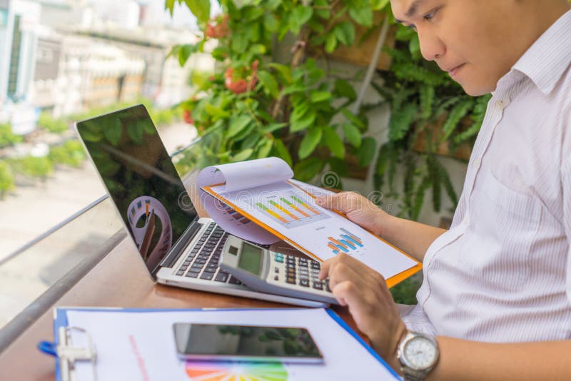 Jonge zakenman die met calculator en financiële verslagen werken stock foto's Jonge zakenman die met calculator en financiële verslagen werken stock foto's