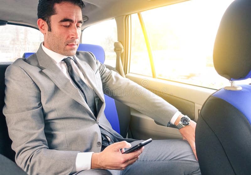 Jonge zakenman in taxi cabine en het texting sms met smartphone stock foto Jonge zakenman in taxi cabine en het texting sms met smartphone stock foto