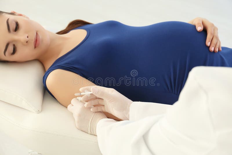 Jonge zwangere vrouw die inenting ontvangen royalty-vrije stock afbeeldingen Jonge zwangere vrouw die inenting ontvangen royalty-vrije stock afbeeldingen
