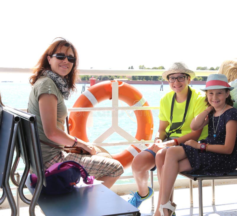 Jongelui die mum met twee jonge geitjes op een Venetiaanse boot glimlachen stock afbeeldingen Jongelui die mum met twee jonge geitjes op een Venetiaanse boot glimlachen stock afbeeldingen